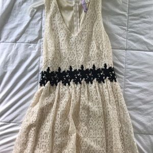Cream, lace dress with black lace detailing.